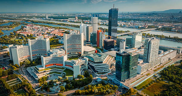 Aerial view of Donau City and UNO City (Vienna International Centre) in Vienna, Austria, featuring a dense cluster of modern skyscrapers and contemporary architecture set along the Danube River. Vienna in Austria, Europe.